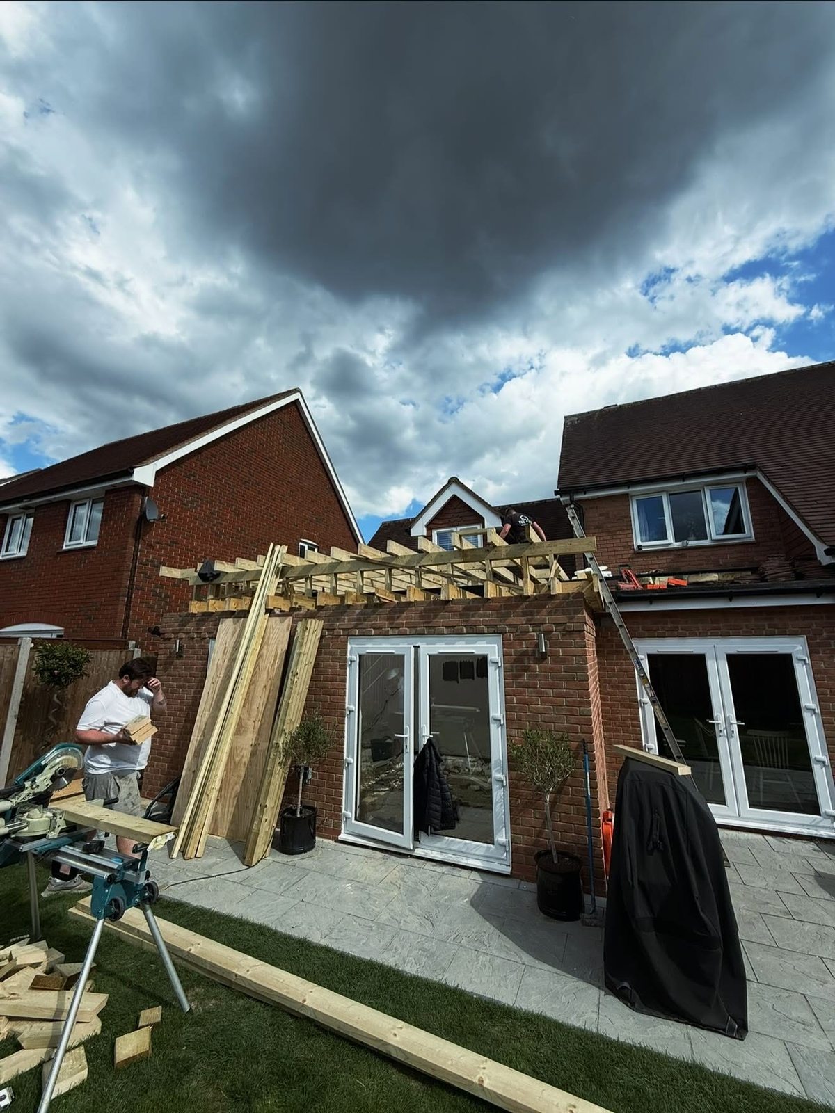 New timber roof structure being built on the brick extension
