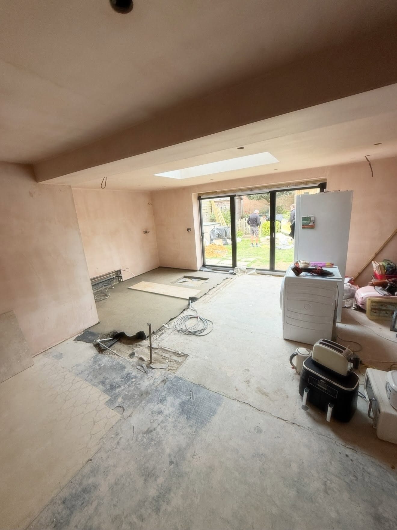 Kitchen extension before completion — freshly plastered walls and bare floor