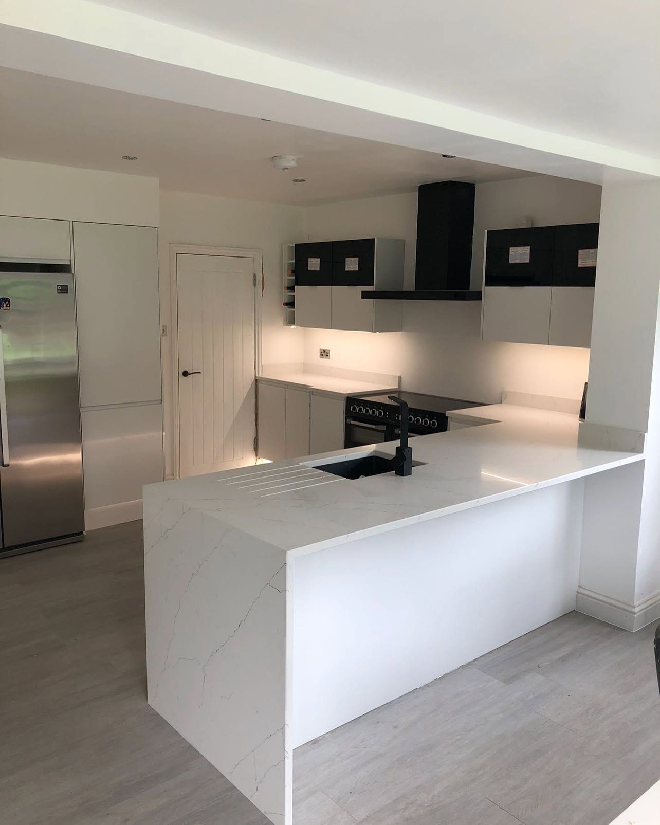 White kitchen with quartz waterfall worktop
